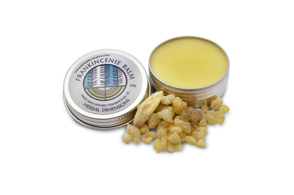 A metal pot of frankincense balm next to a pile of resin
