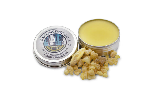 A metal pot of frankincense balm next to a pile of resin